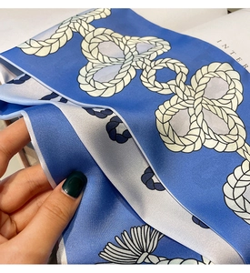 Gros plan du motif de nœud de corde nautique bleu et blanc sur un tissu en soie