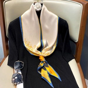 Close-up of elegant silk scarf with oil painting pattern tied on black sweater
