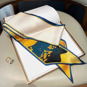 Detail of elegant silk-like scarf with abstract fish print and pearl decorative ring