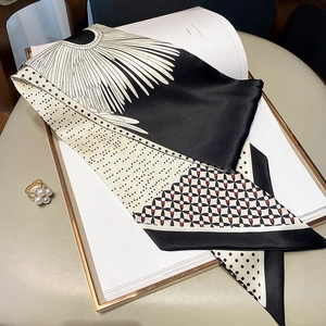 Detail shot of black and white silk scarf with geometric patterns on elegant book background