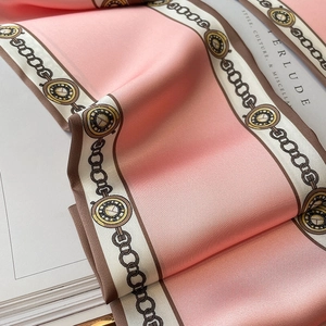 Nahaufnahme eines rosa Seidenschals mit Vintage-Uhrenmuster und glatter Textur