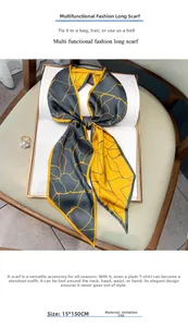 Dettaglio di una sciarpa in finta seta 15x150cm con motivi geometrici su sedia in pelle