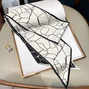 Dettaglio foulard in seta double-face con motivi geometrici screpolati bianchi e neri