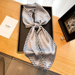 Élégant foulard en satin à bordure pied-de-poule sur table en bois avec accessoires