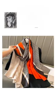 Detail of silk scarf with orange and brown geometric patterns draped on a hanger