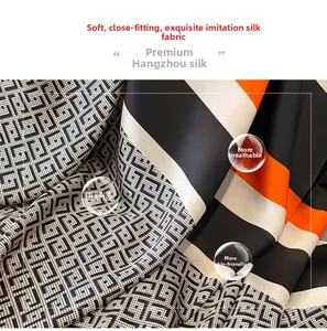 Detail of silk-like scarf featuring geometric grid pattern and bold orange stripes