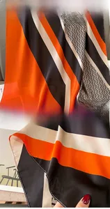 Detailed view of striped silk scarf featuring classic monogram patterns and fine edge stitching