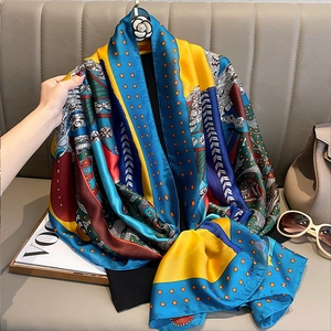 Elegant vintage silk scarf with colorful geometric prints draped over a stylish leather bag