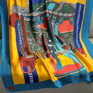 Detail of silk scarf with equestrian horse motifs and bright yellow and blue patterns