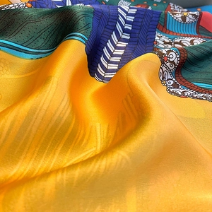Detailed close-up of premium silk scarf with vibrant floral patterns and smooth texture