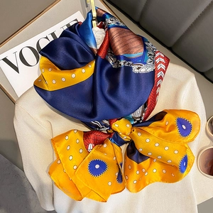 Detail of silk scarf with retro geometric patterns and white polka dots on sweater
