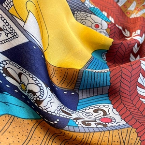 Macro shot of colorful silk scarf showing smooth satin texture and artistic abstract patterns