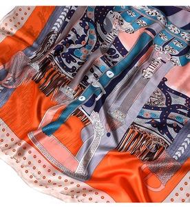 Detail of premium silk scarf featuring retro equestrian buckles and vibrant orange patterns