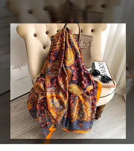 Close-up of orange paisley floral satin scarf with elegant drapes and glossy texture
