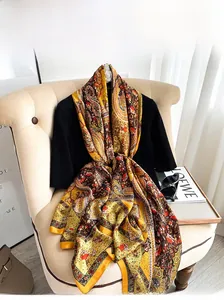 Detail of floral paisley print silk scarf draped on clothing in a cozy home setting