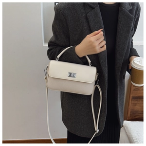 Detail of cream white leather satchel with silver twist lock and minimalist handle