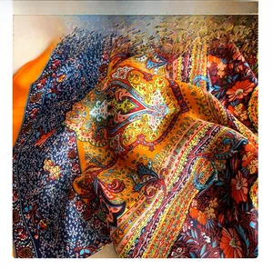 Macro shot of paisley floral silk scarf showing premium stitching and vibrant patterns
