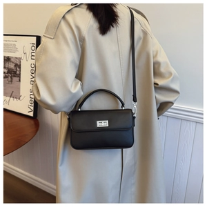 Detailed view of black crossbody square bag featuring mixed leather texture and silver clasp