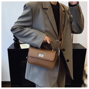 Detail of a brown leather shoulder bag with contrast texture and silver swivel lock