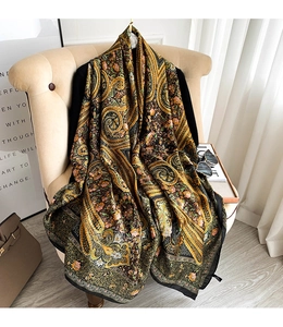 Detail of bohemian paisley print silk scarf draped on a chair with vintage floral patterns