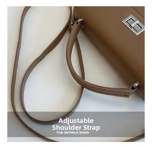 Detail showing the adjustable leather strap and silver twist lock on the brown bag