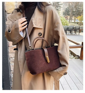 Detail view of the vintage brown suede tote bag with antique bronze metal lock hardware