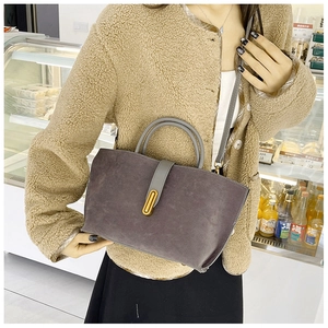 Close-up of deep purple matte suede tote bag with elegant gold metal buckle and grey handles