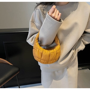 Detail of mustard yellow quilted cloud bag in crescent shape with padded handle