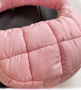 Detailed macro view of the pink quilted fabric and soft texture on the padded cloud bag