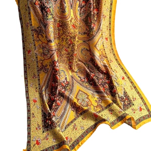 Yellow paisley silk scarf with traditional floral patterns and smooth satin finish