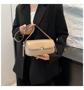 Dettaglio borsa in pelle beige con fibbia dorata quadrata e trama raffinata