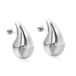 Macro shot of polished silver water drop earrings showing sleek reflective surface