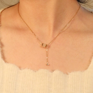 Collier élégant en acier inoxydable doré avec pendentif cylindre et pompon délicat