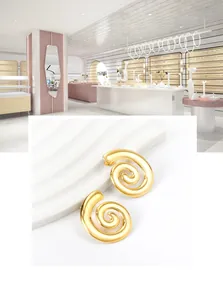 Detail of 18K gold-plated spiral earrings with polished finish on a white display
