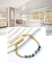 Detailed close-up of gold stainless steel bracelet with blue patterned eye beads