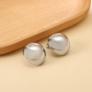 Polished silver semicircular stud earrings in a minimalist metal design on wood tray