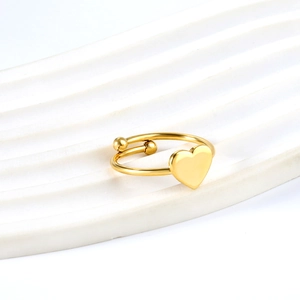 Polished gold heart open ring made of stainless steel on white minimalist background