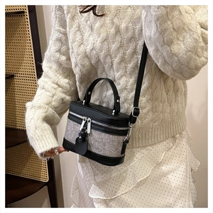 Detail of a retro box bag featuring grey fabric stitching and silver hardware accents