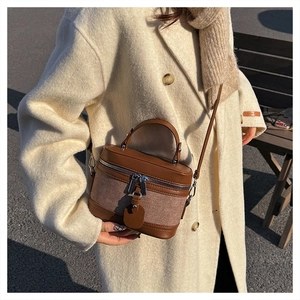 Detail showing vintage box bag with brown leather patchwork and dual zipper closure
