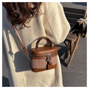 Outdoor shot of the vintage two-tone brown box bag with leather straps and top handle
