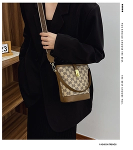 Model wearing a vintage monogram bucket bag with leather trim and wide shoulder strap