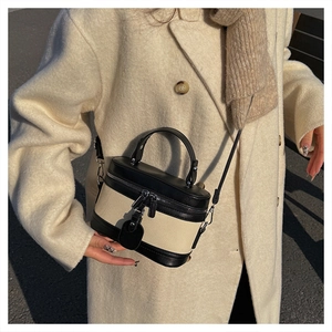Detail of vintage canvas and leather contrast stitching box bag with adjustable strap