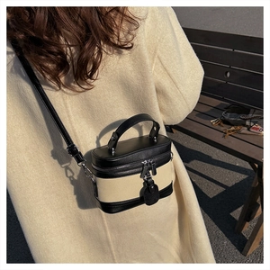 Detail of contrast stitch mini box bag with dual zippers and leather crossbody strap