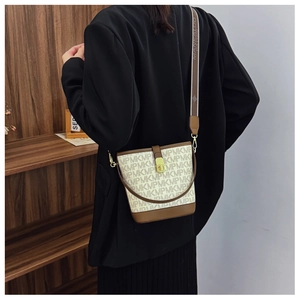 Detail of printed bucket bag with monogram pattern and adjustable shoulder strap