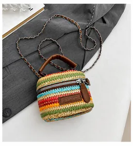 Detail van de kleurrijke gevlochten strozak met lederen patch en metalen ketting