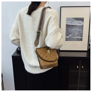 Detail of vintage brown printed bucket bag with wide jacquard strap and metal buckle