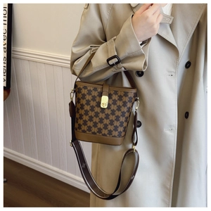 Detail of vintage brown printed bucket bag with golden buckle and wide shoulder strap
