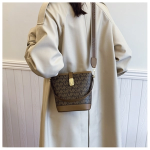 Brown bucket bag with logo print and adjustable wide shoulder strap shown on model