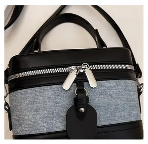 Detail view of smooth silver metal double zippers on blue denim vanity crossbody bag