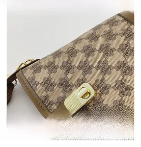 Close-up of golden metal twist lock and monogram print on the vintage handbag